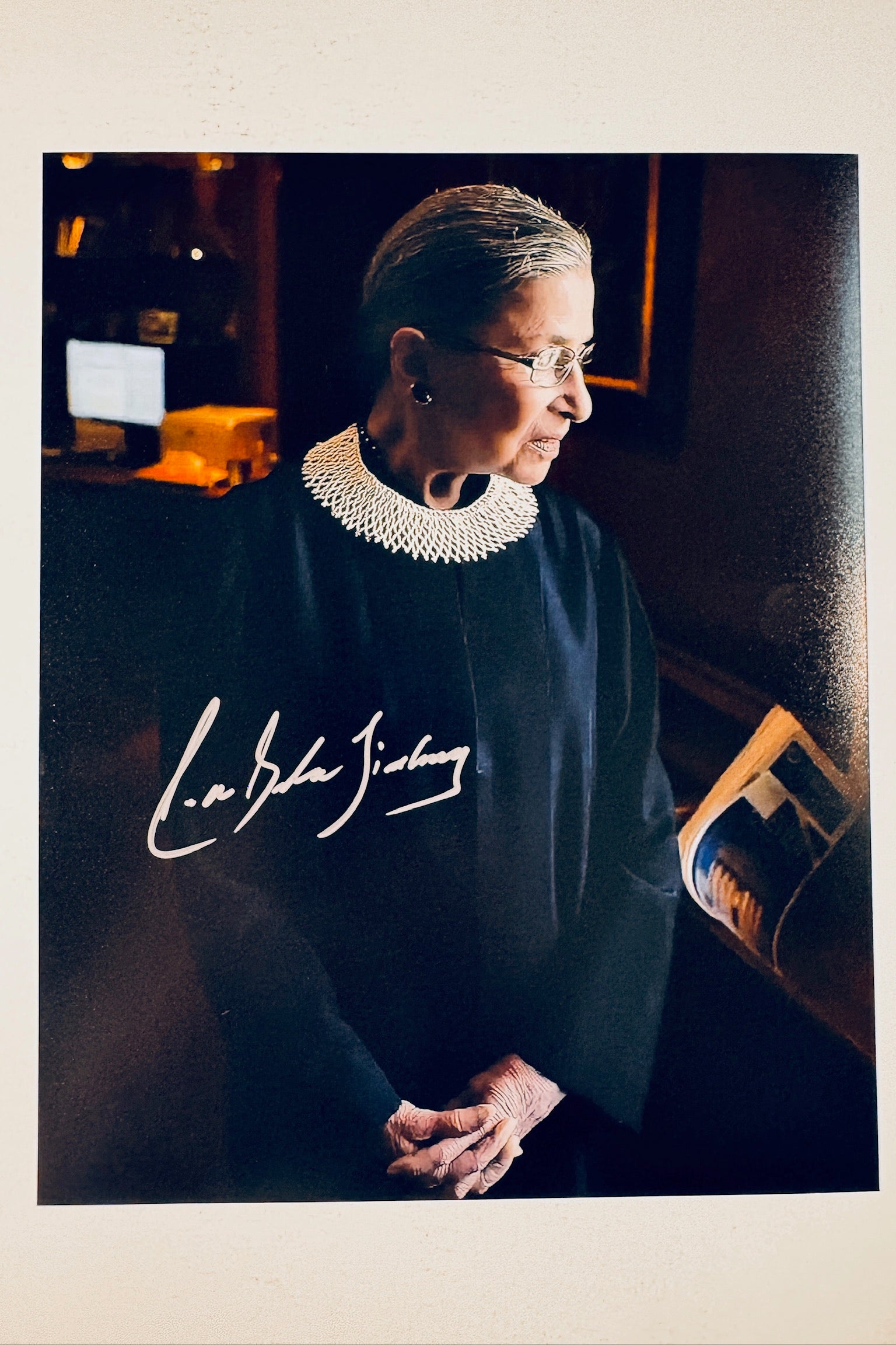 Ruth Bader Ginsburg hand-signed 8x10 matte photo wearing her judicial robe and lace collar.