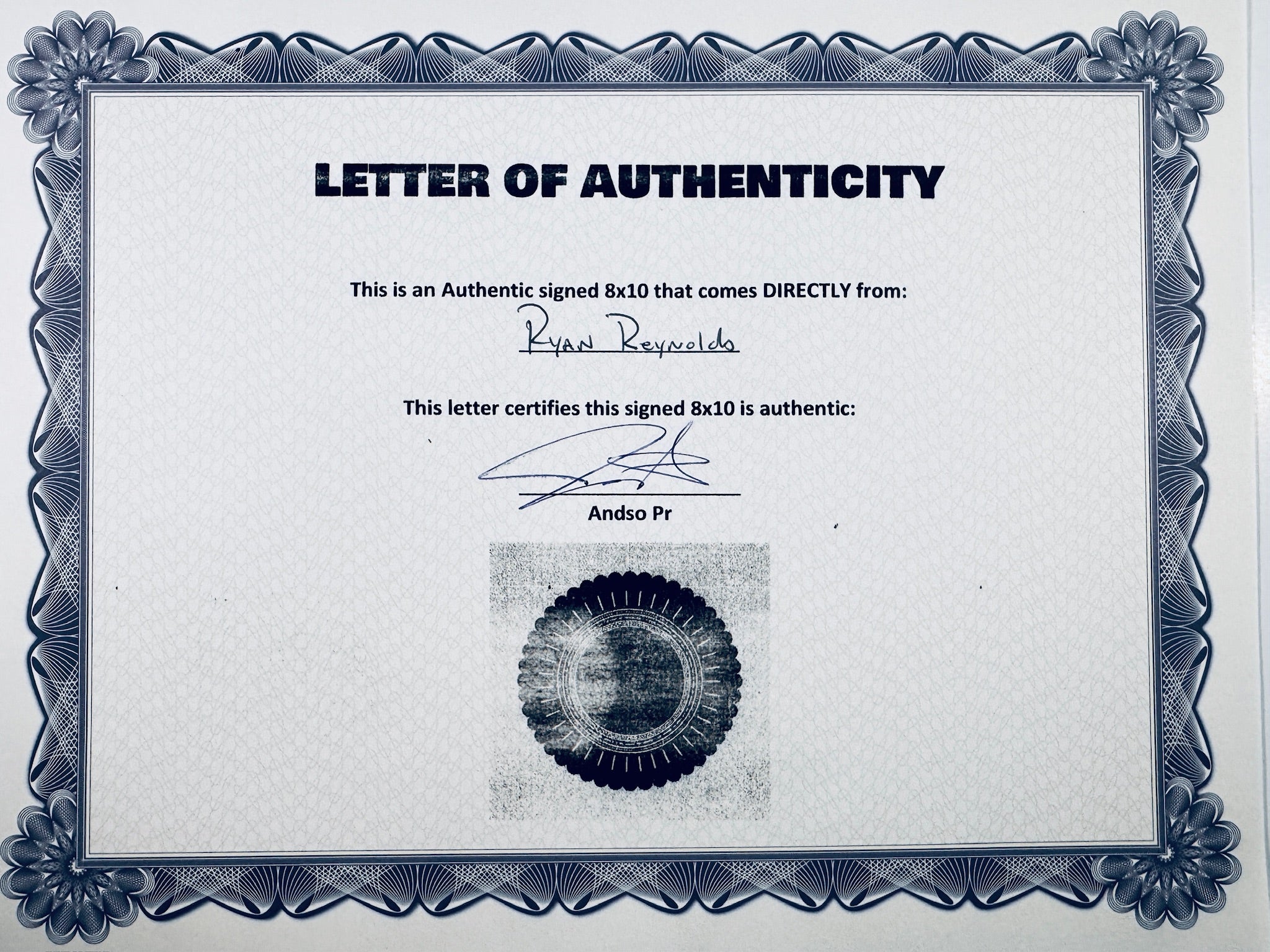 A Letter of Authenticity with a decorative blue-patterned border, certifying an authentic signed 8x10 coming directly from Ryan Reynolds, featuring a dark circular seal graphic at the bottom.