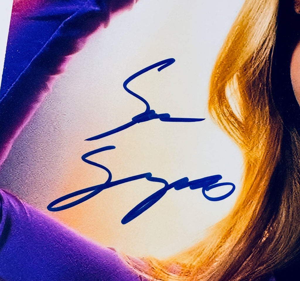 Close-up of Sara Sampaio's signature in blue marker on the signed Superman 8x10 photo.