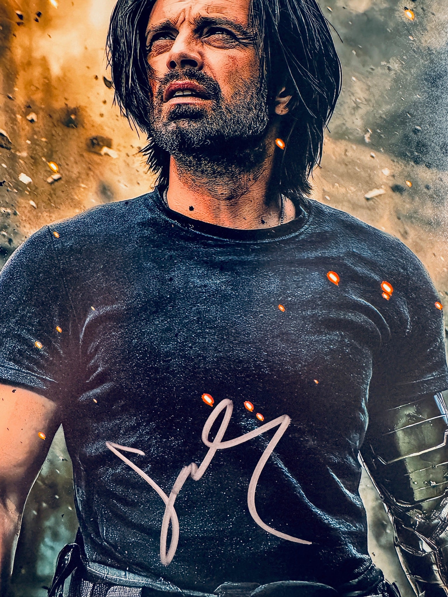 Close-up view of Sebastian Stan's signature in silver marker on the promotional matte photo.