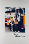 Full front view of autographed 8x10 color photo featuring The Partridge Family cast standing outside their famous bus, signed Love, Shirley Jones in black marker below.