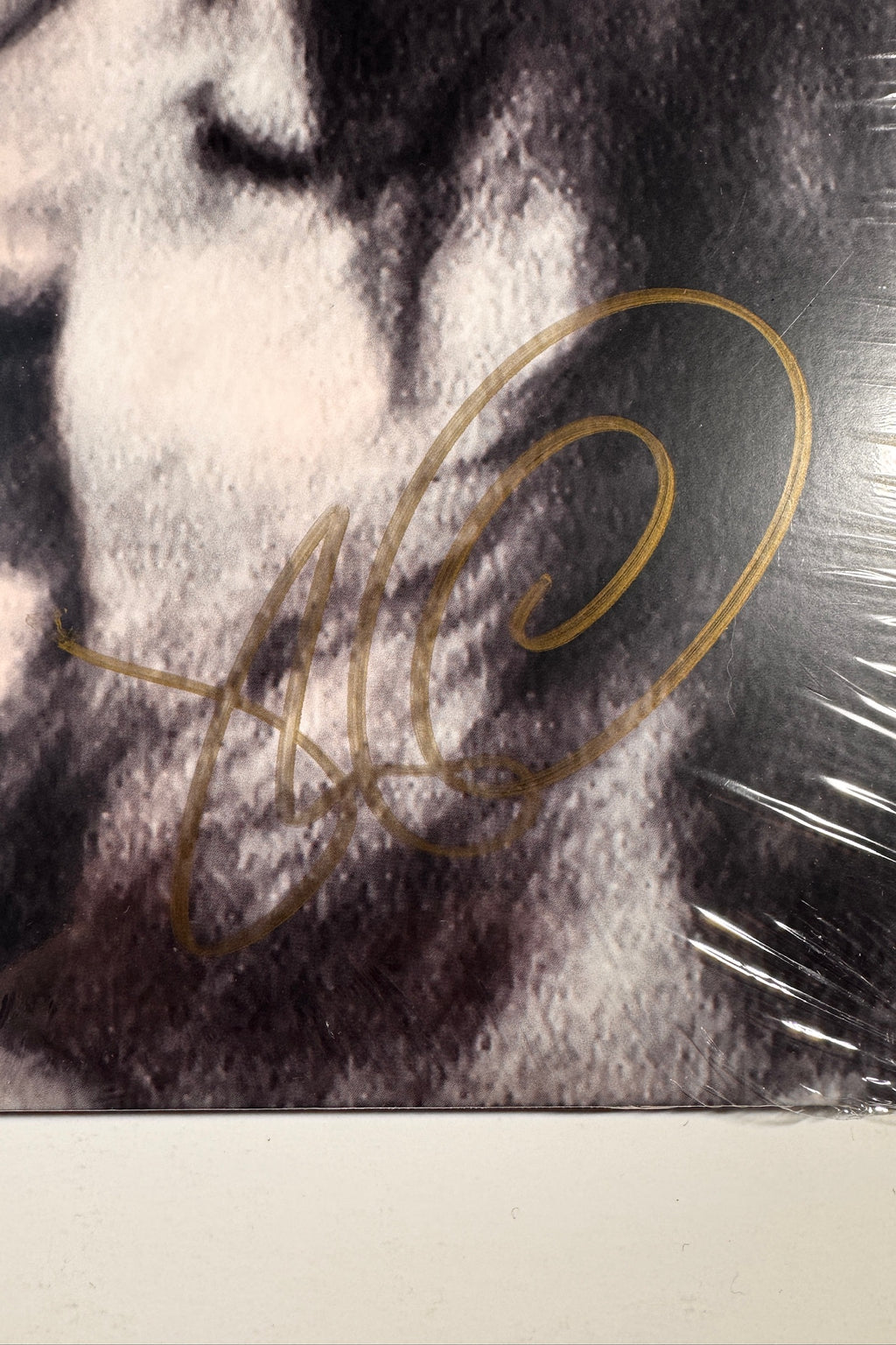 Close-up view of the metallic gold hand signature autographed on the front jacket of the Tame Impala Deadbeat vinyl record.