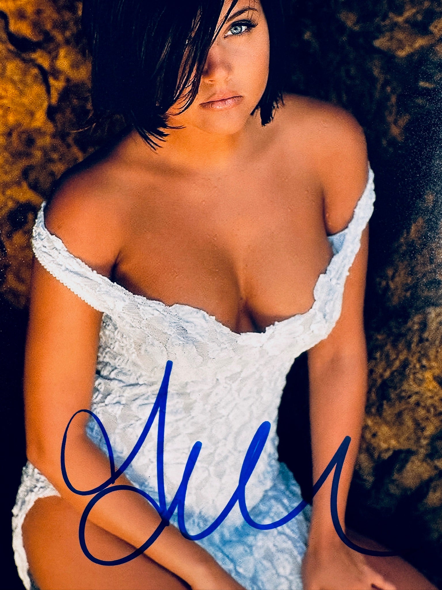 Close-up view of Tiffani Amber Thiessen's signature in blue marker across the promotional photo.