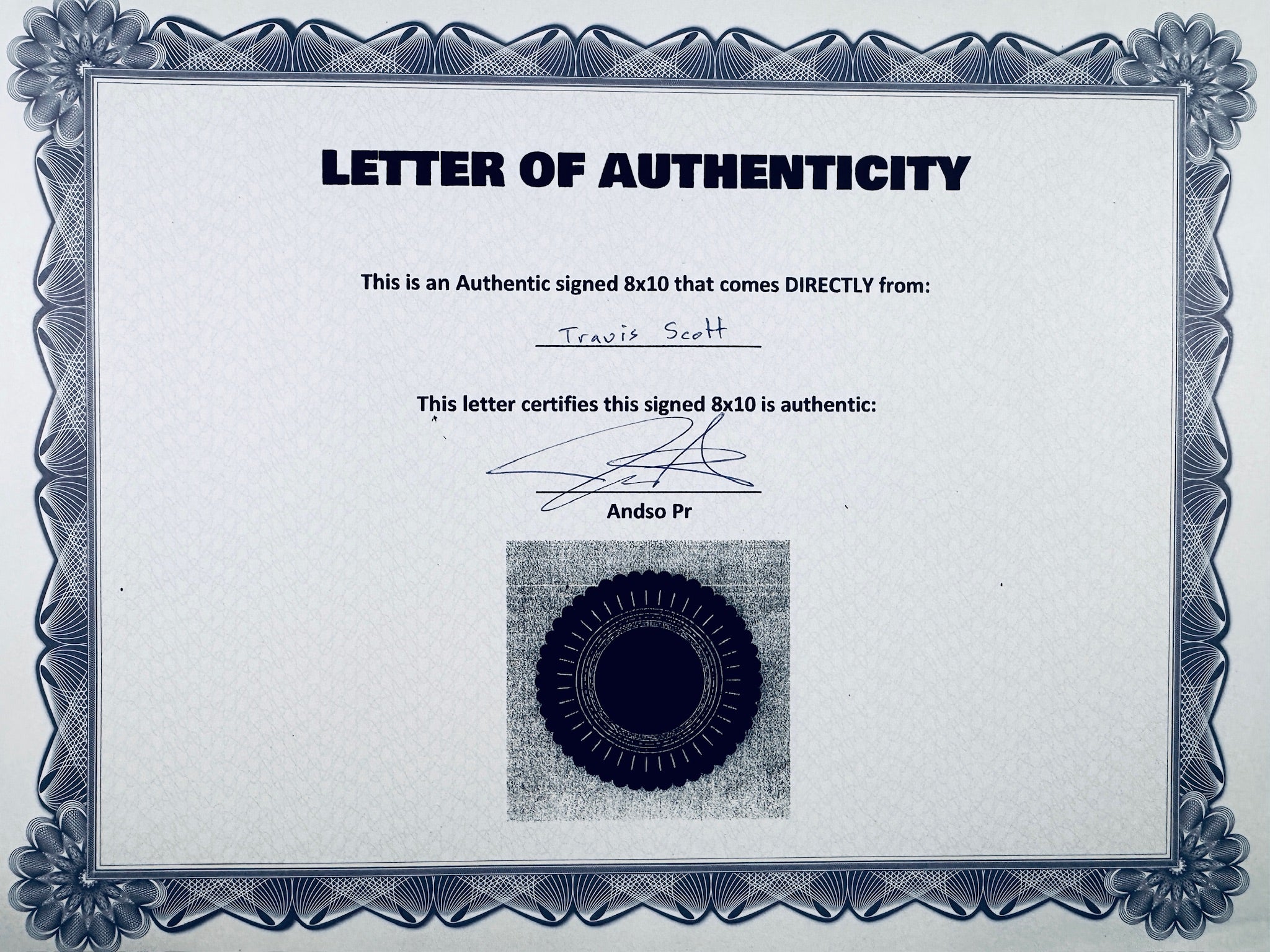 A Letter of Authenticity with a decorative blue-patterned border, certifying an authentic signed 8x10 coming directly from Travis Scott, featuring a dark circular seal graphic at the bottom.