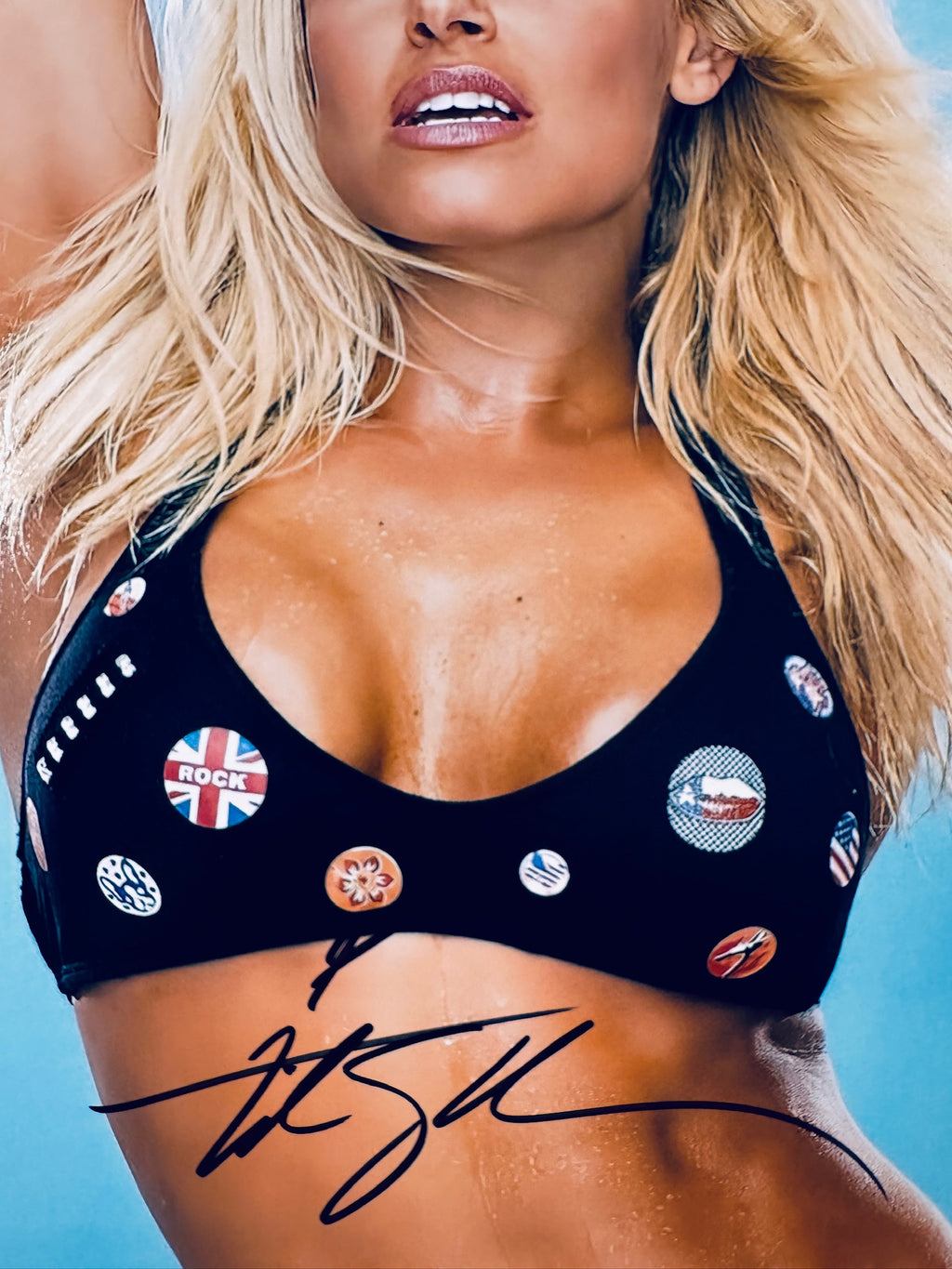 Close-up view of Trish Stratus's signature in black marker across the WWE promotional matte photo.