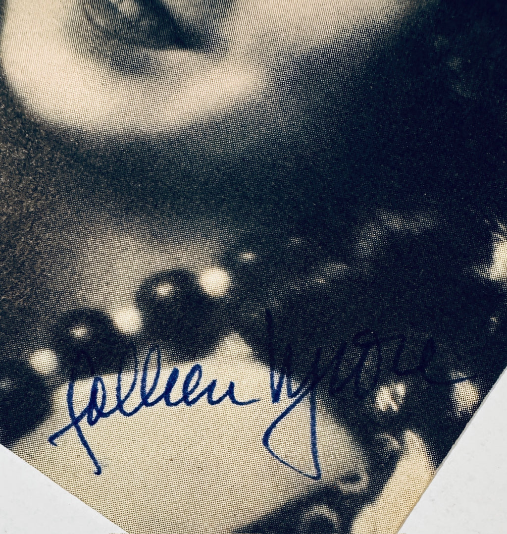 Macro close-up showing live blue fountain pen ink strokes overlapping the visible printed halftone rosette pattern dots of a vintage 1920s paper magazine clipping.