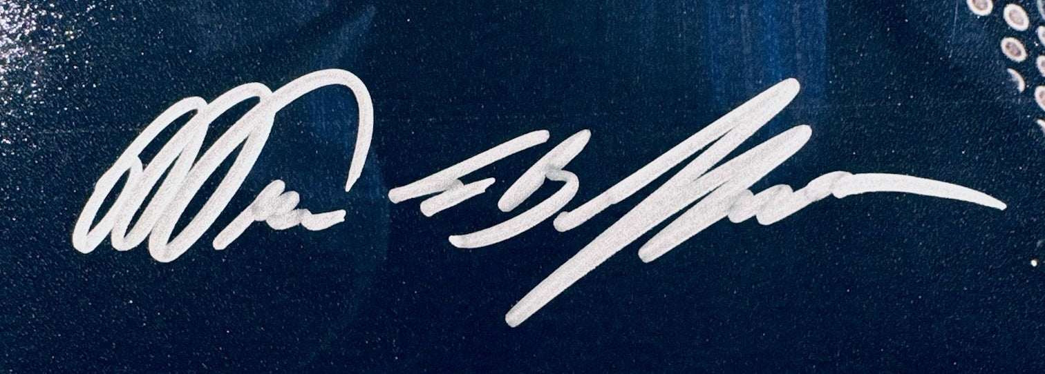 A close-up view showing the authentic hand-signed signature of Warren Buffett on a photograph.