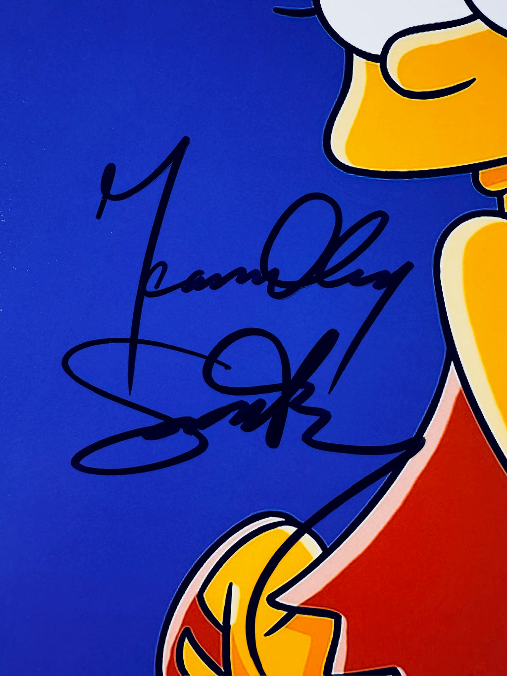 Close-up of Yeardley Smith's signature in black marker on the signed Lisa Simpson 8x10 photo.
